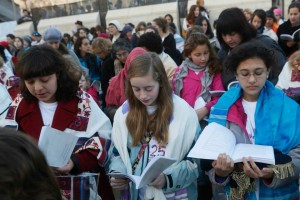 Eliza Moss-Horwitz, Lucy Sattler and Alexandra Schwartz pray with Women of the Wall. Schwartz (right) holds an empty Torah cover beneath her prayer book, symbolizing the Torah scroll the group was prevented from bringing in to the Kotel plaza.