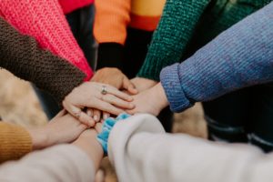 Eight people's hands joined together in the center