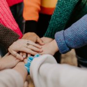Eight people's hands joined together in the center